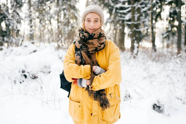 portrait of beautiful woman with scarf in winter forest