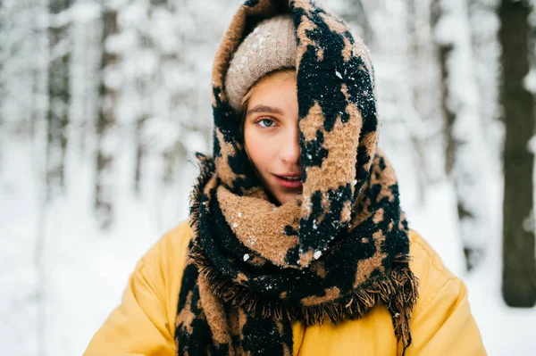 portrait of beautiful woman with scarf in winter forest