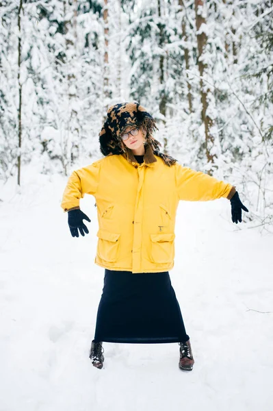 雪に覆われた冬の森で黄色のコートで美しい若い女性 — ストック写真