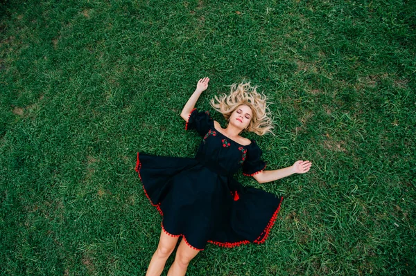 緑の芝生で休んで黒のドレスで美しい女性のオーバー ヘッド ビュー — ストック写真