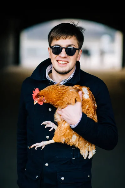 通りに立っている鶏を持つスタイリッシュな男 — ストック写真