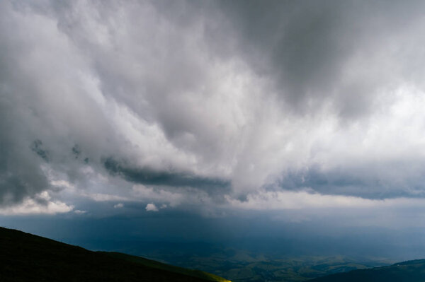 scenic view of storm rainy clouds over mountain hills