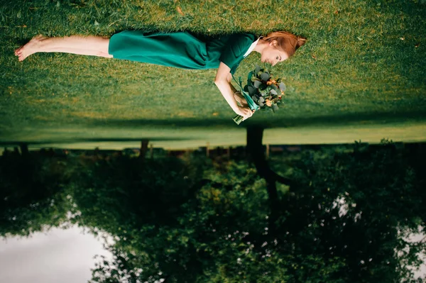 Mladá Zrzka Žena Zelených Šatech Kyticí Létě Leží Zelené Trávě — Stock fotografie