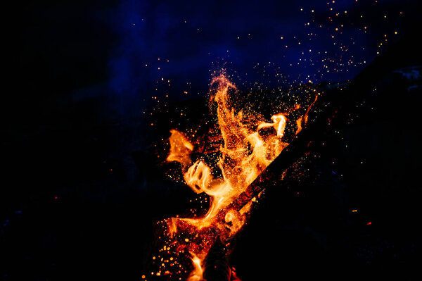 закрыть вид на горящий костер как на темный фон
