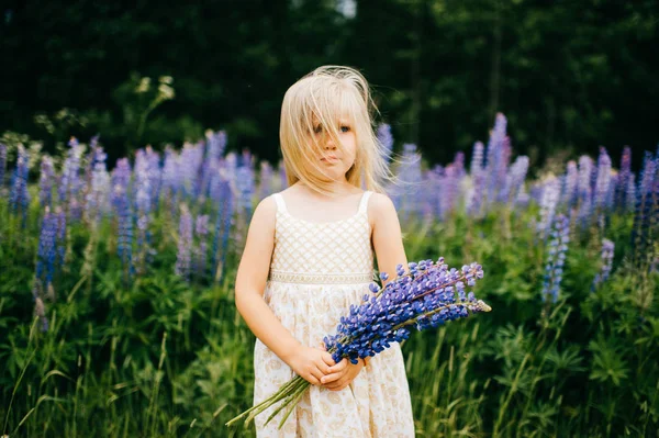 Blond Meisje Witte Jurk Bedrijf Boeket Van Lupine Veld — Stockfoto