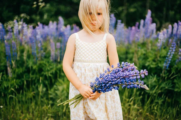 Blond Flicka Vit Klänning Holding Bukett Lupiner Fältet — Stockfoto