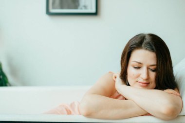 Genç güzel kadın boş Vintage dökme demir banyoda yatıyor