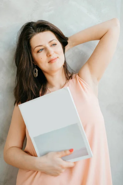 Jonge Vrouw Met Wit Tijdschrift Handen Poseren Tegen Grijze Muur — Stockfoto