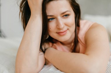 Güzel esmer kadın sabah evde beyaz yatakta yatan