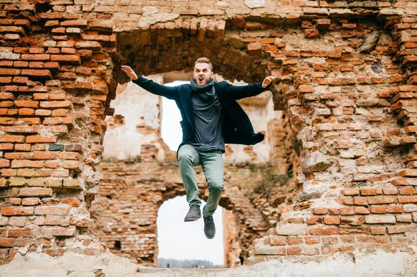 背景に遺跡のレンガ壁からジャンプ男 — ストック写真