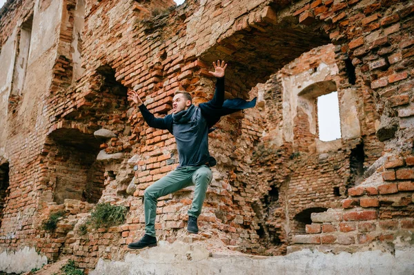 背景に遺跡のレンガ壁からジャンプ男 — ストック写真