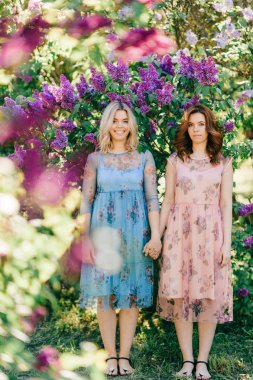  Genç ikiz kardeşler çiçeklenme içinde farklı elbiseler Botanik Bahçesi yaz