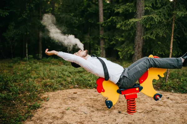 Man Formal Wear Smoking While Riding Childish Horse Attraction — Stock Photo, Image