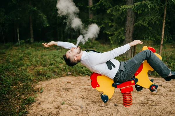 Hombre Desgaste Formal Fumar Mientras Monta Atracción Infantil Caballo — Foto de Stock