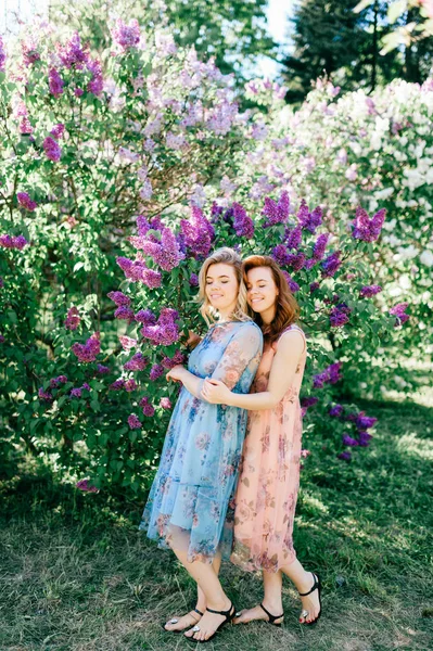 Mooie Jonge Tweelingzusjes Verschillende Jurken Tijdens Bloei Zomer Botanische Tuin — Stockfoto