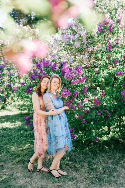Mooie Jonge Tweelingzusjes Verschillende Jurken Tijdens Bloei Zomer Botanische Tuin — Stockfoto