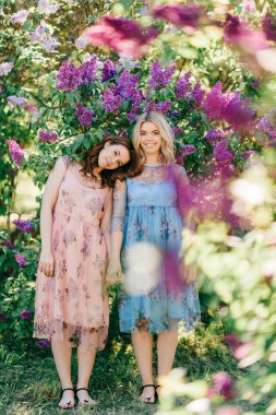  Genç ikiz kardeşler çiçeklenme içinde farklı elbiseler Botanik Bahçesi yaz