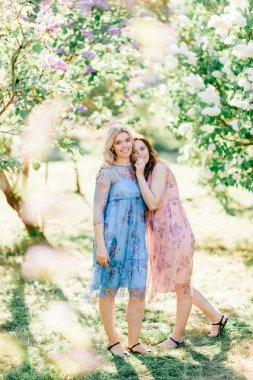  Genç ikiz kardeşler çiçeklenme içinde farklı elbiseler Botanik Bahçesi yaz