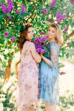  Genç ikiz kardeşler çiçeklenme içinde farklı elbiseler Botanik Bahçesi yaz