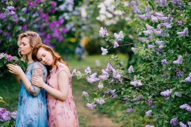  Genç ikiz kız çiçek leylak botanik bahçesi içinde ihale