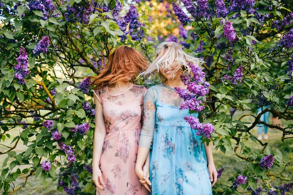 若い双子姉妹に咲くライラック植物園 — ストック写真