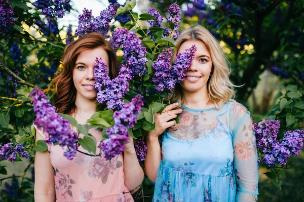若い入札ライラック咲く植物園で双子の姉妹 — ストック写真