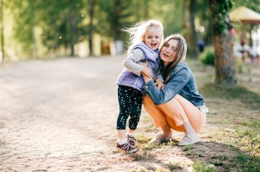 Genç mutlu anne ve küçük kızı Park