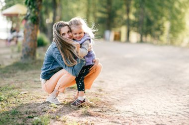 Genç mutlu anne ve küçük kızı Park