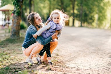 Genç mutlu anne ve küçük kızı Park