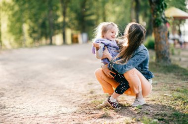 Genç mutlu anne ve küçük kızı Park