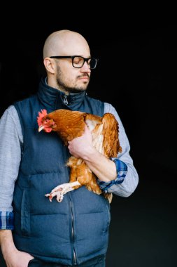 Gözlük tavuk elinde tutan genç adam