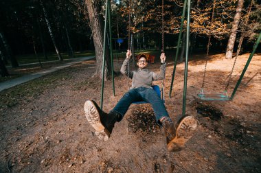 Bahçesi yaz parkta salıncakta sallanan yetişkin adam