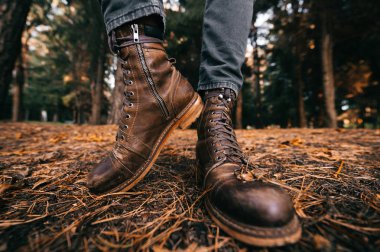 kırpılmış çekim vintage deri adam ayakta sonbahar ormanda çizme.