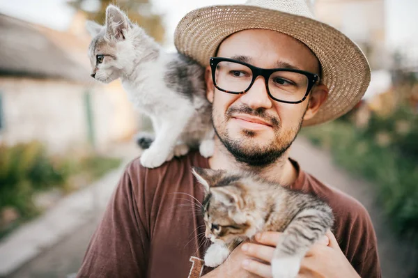 村で小さな子猫と若いのひげを生やした男の肖像 — ストック写真