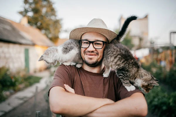 村で小さな子猫と若いのひげを生やした男の肖像 — ストック写真