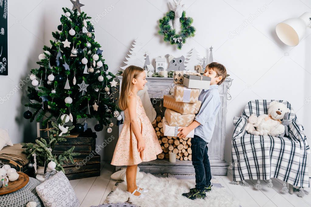 adorable kids with gifts in decorated christmas and new year studio