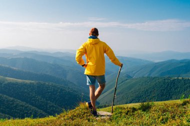 arkadan görünüşü Karpat Dağları üstüne sarı yağmurluk erkekte ufuktan zirvesinin Manzaralı