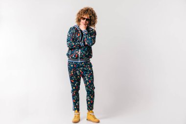 evde poz Modern giyimleri kıvırcık saçlı Genç adam