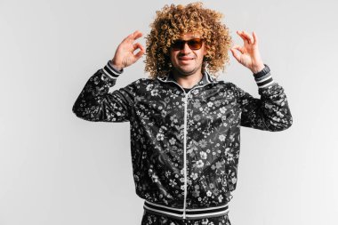 evde poz Modern giyimleri kıvırcık saçlı Genç adam