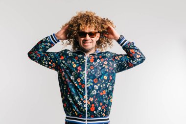 evde poz Modern giyimleri kıvırcık saçlı Genç adam