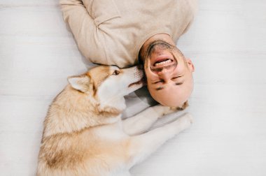 husky köpek ile katta yatan adam