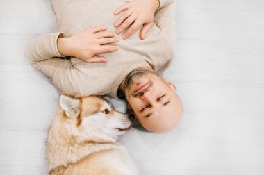 husky köpek ile katta yatan adam