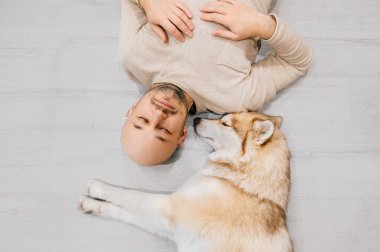 husky köpek ile katta yatan adam