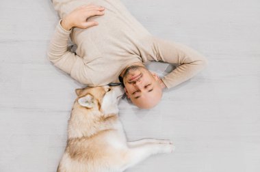 husky köpek ile katta yatan adam