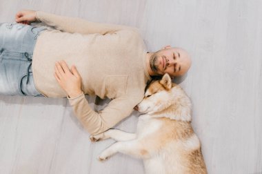 husky köpek ile katta yatan adam