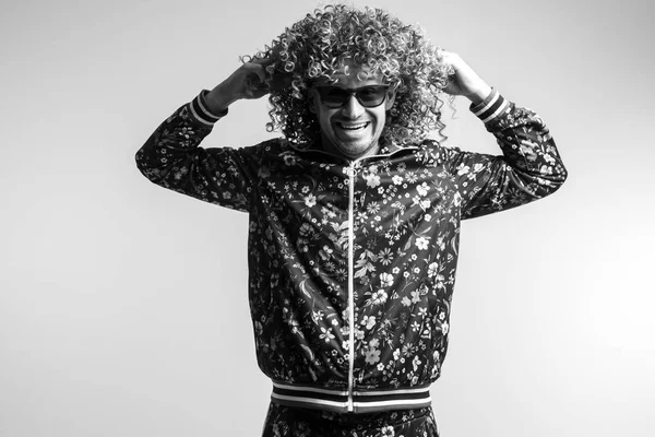 evde poz Modern giyimleri kıvırcık saçlı Genç adamın siyah beyaz fotoğraf