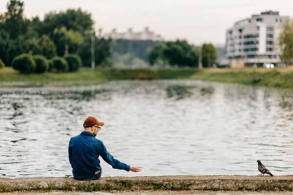 lonely man sitting on edge of embankment outdoor