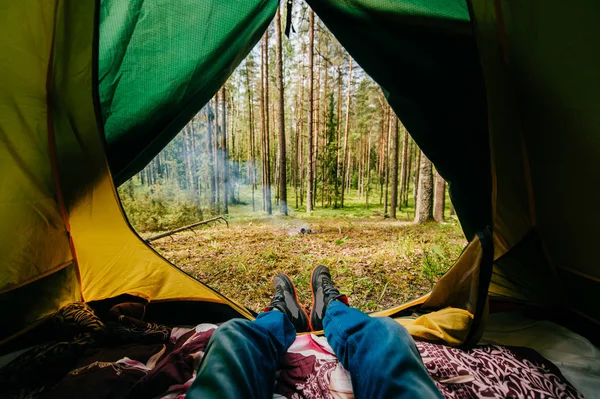森のキャンプのテントで休んでいる人の部分的なビュー — ストック写真