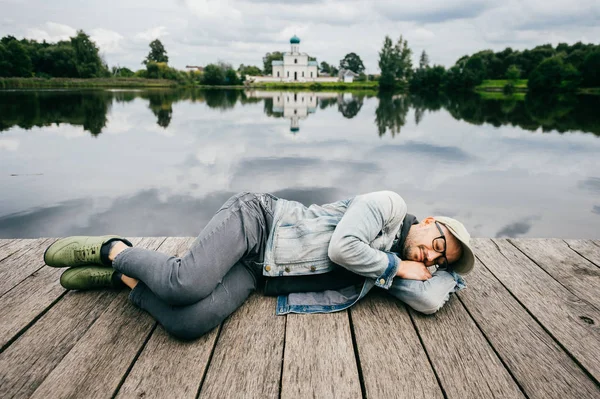 Homem Descansando Ponte Madeira Lago Com Água Refletida — Fotografia de Stock