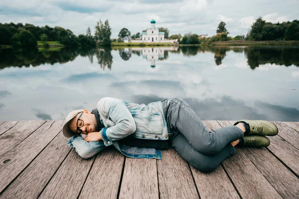 Homem Descansando Ponte Madeira Lago Com Água Refletida — Fotografia de Stock